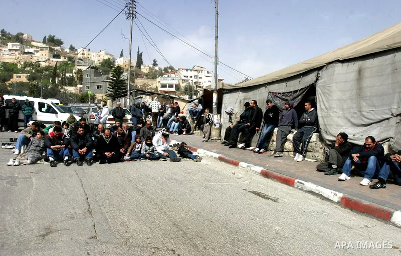 Palestinians pray on a street outside a protest tent during Friday noon prayers on 17 Feb 2012 in the Silwan neighborhood of East Jerusalem. Silwan is seen behind.. Photo by Mahfouz Abu Turk
