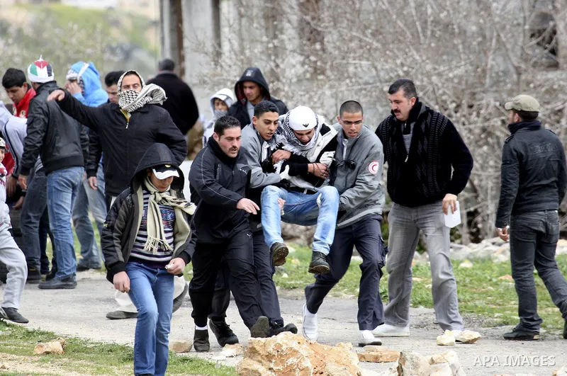 An injured Palestinian protestor is evacuated by medics in the village of Kufr Qaddum, during a protest against the expansion of the nearby Jewish settlement of Kdumim, in the northern West Bank, Friday, Feb. 17, 2012. P...