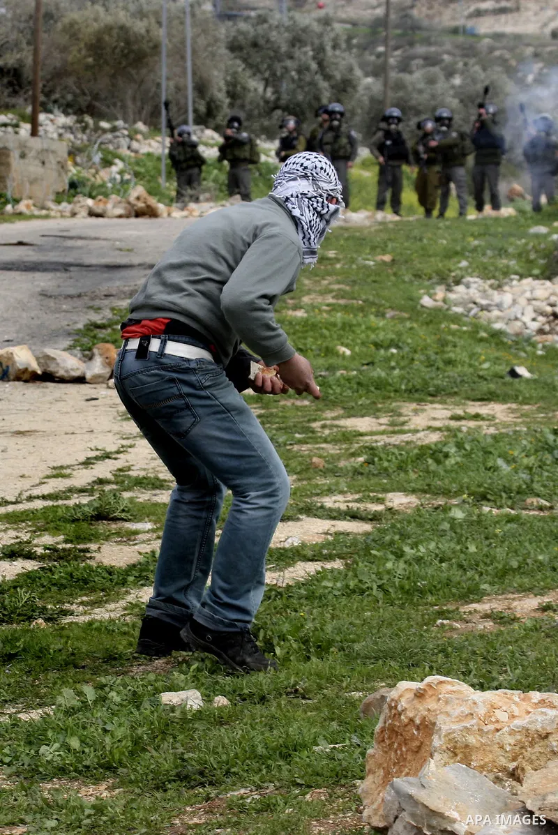 Palestinian youths hurl stones at Israeli troops during a protest in the village of Kufr Qaddum against the expansion of the nearby Jewish settlement of Kdumim, in the northern West Bank, Friday, Feb. 17, 2012. Photo by...