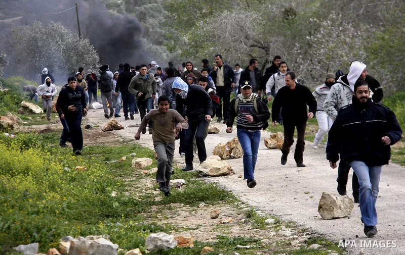 Palestinian youths hurl stones at Israeli troops during a protest in the village of Kufr Qaddum against the expansion of the nearby Jewish settlement of Kdumim, in the northern West Bank, Friday, Feb. 17, 2012. Photo by...