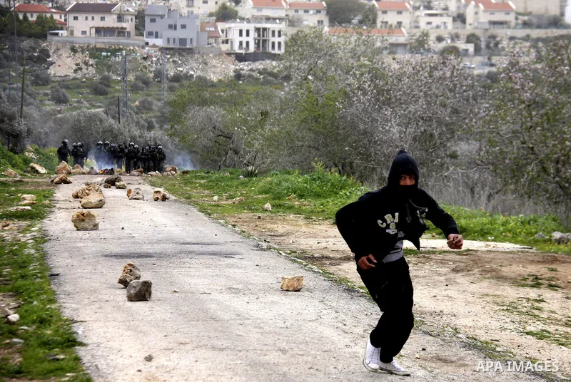 Palestinian youths hurl stones at Israeli troops during a protest in the village of Kufr Qaddum against the expansion of the nearby Jewish settlement of Kdumim, in the northern West Bank, Friday, Feb. 17, 2012. Photo by...