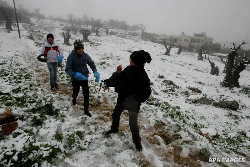 Palestinians play with snow in the West Bank city of Hebron on February 18, 2012. Photo by Mamoun Wazwaz