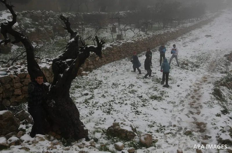 Palestinians play with snow in the West Bank city of Hebron on February 18, 2012. Photo by Mamoun Wazwaz