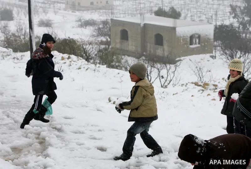 Palestinians play with snow in the West Bank city of Hebron on February 18, 2012. Photo by Mamoun Wazwaz