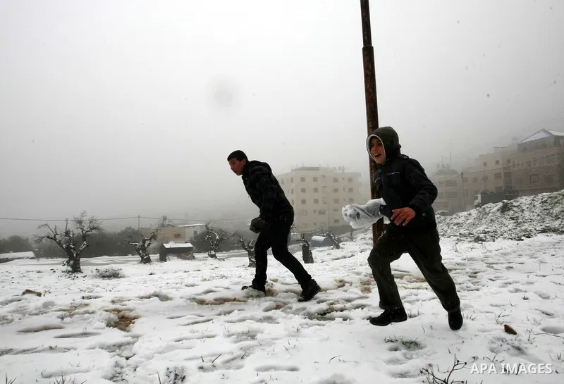 Palestinians play with snow in the West Bank city of Hebron on February 18, 2012. Photo by Mamoun Wazwaz