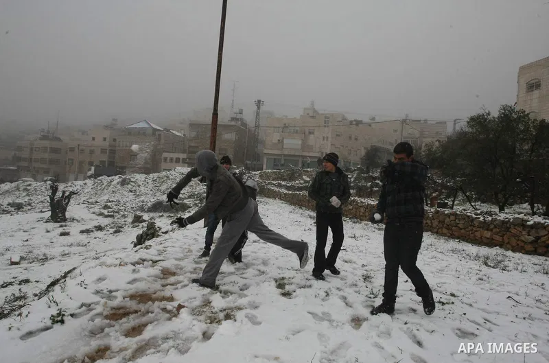 Palestinians play with snow in the West Bank city of Hebron on February 18, 2012. Photo by Mamoun Wazwaz