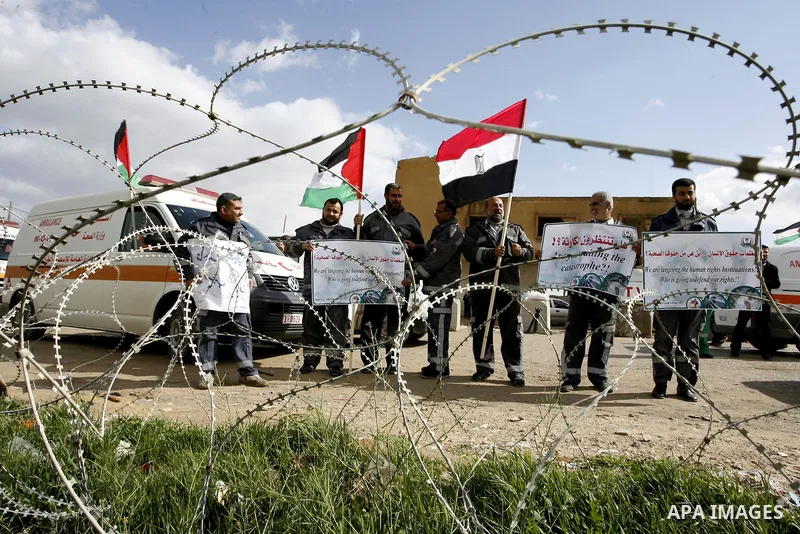 Palestinians attend a rally in front of the Rafah border crossing with Egypt on February 18, 2012 during a sit-in by dozens of emergency crews and ambulance workers demanding Egypt provide the Gaza Strip with electricity...