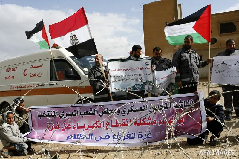 Palestinians attend a rally in front of the Rafah border crossing with Egypt on February 18, 2012 during a sit-in by dozens of emergency crews and ambulance workers demanding Egypt provide the Gaza Strip with electricity...
