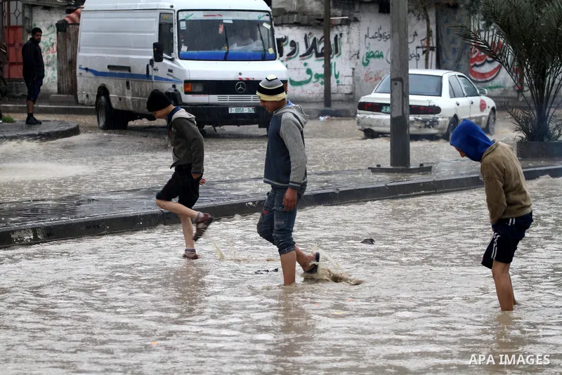 Palestinian boys walk in a street during the heavy rain of the winter, in the Gaza City, Feb. 19, 2012. Photo by Mohammed Asad