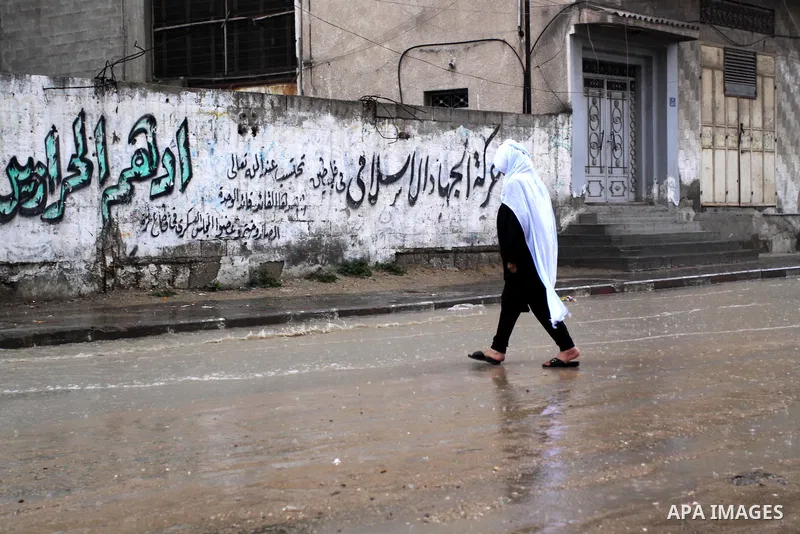 Palestinian woman walk in a street during the heavy rain of the winter, in the Gaza City, Feb. 19, 2012. Photo by Mohammed Asad
