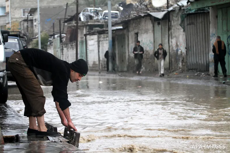 Palestinians walk in a street during the heavy rain of the winter, in the Gaza City, Feb. 19, 2012. Photo by Mohammed Asad