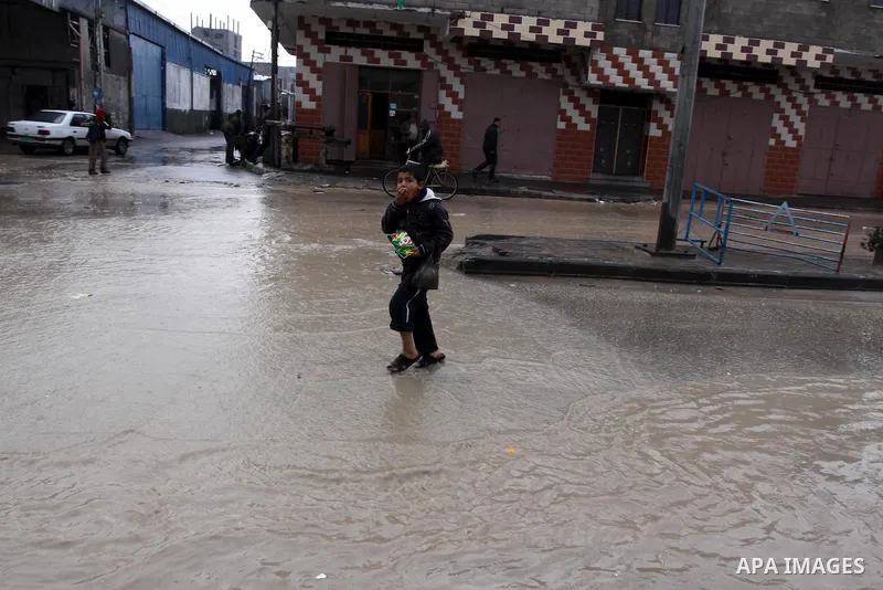 Palestinian boys walk in a street during the heavy rain of the winter, in the Gaza City, Feb. 19, 2012. Photo by Mohammed Asad