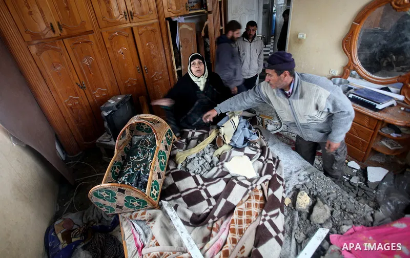 A Palestinian woman reacts as she surveys her bedroom which was damaged in an Israeli air strike in Gaza City on Saturday night February 19, 2012. Photo by Ashraf Amra