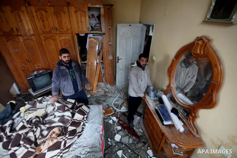 Palestinians look at the damage to house after an Israeli air strike in Gaza City February 19, 2012. Photo by Ashraf Amra