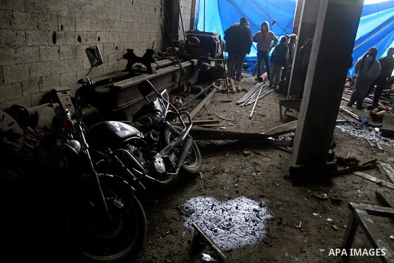 Palestinians look at what they said is a metal workshop which was damaged in an Israeli air strike on Saturday night in Gaza City February 19, 2012. Photo by Ashraf Amra