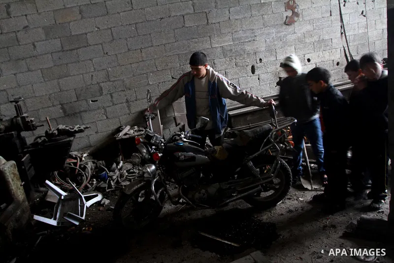 Palestinians look at what they said is a metal workshop which was damaged in an Israeli air strike on Saturday night in Gaza City February 19, 2012. Photo by Ashraf Amra
