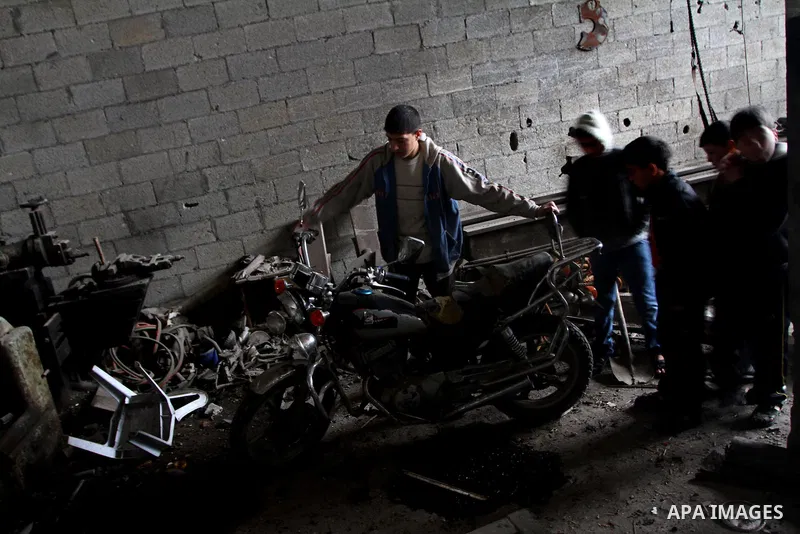 Palestinians look at what they said is a metal workshop which was damaged in an Israeli air strike on Saturday night in Gaza City February 19, 2012. Photo by Ashraf Amra