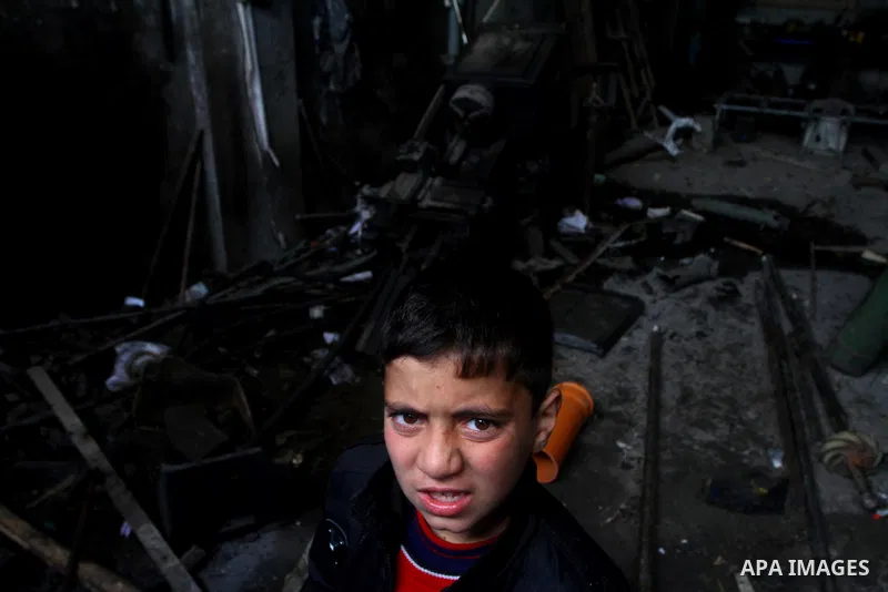 A Palestinian boy looks at what Palestinians said is a metal workshop which was damaged in an Israeli air strike on Saturday night in Gaza City February 19, 2012. Photo by Ashraf Amra