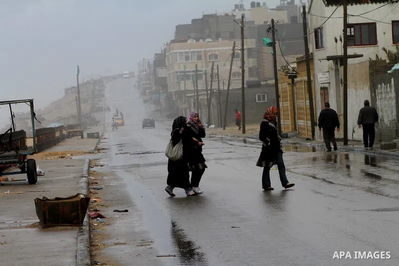 Palestinians walk in a street during the heavy rain of the winter, in the Gaza City, Feb. 19, 2012. Photo by Ashraf Amra