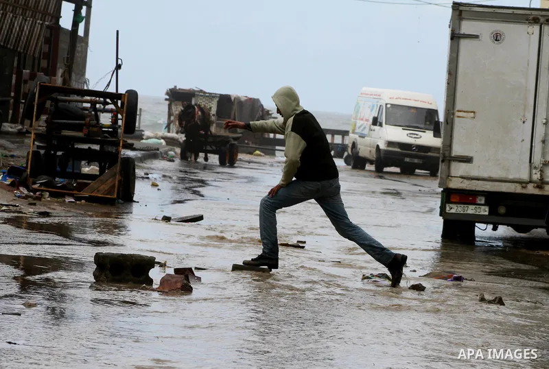 Palestinians walk in a street during the heavy rain of the winter, in the Gaza City, Feb. 19, 2012. Photo by Ashraf Amra