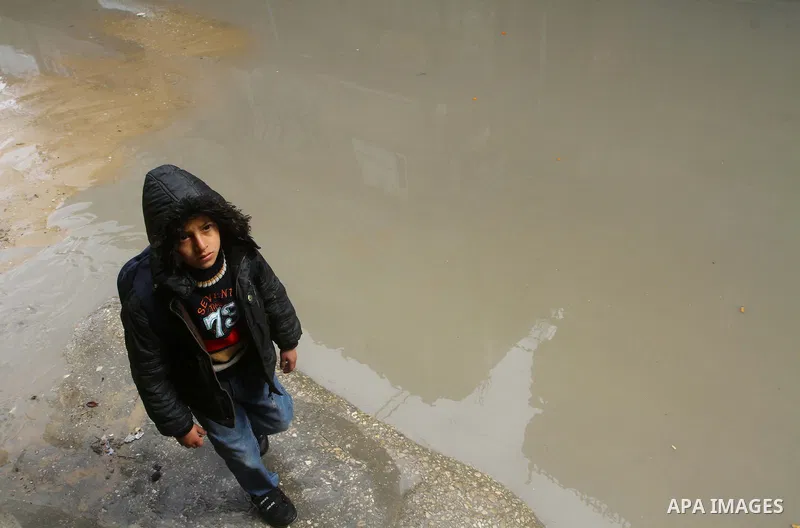 Palestinians walk in a street during the heavy rain of the winter, in the Gaza City, Feb. 19, 2012. Photo by Ashraf Amra