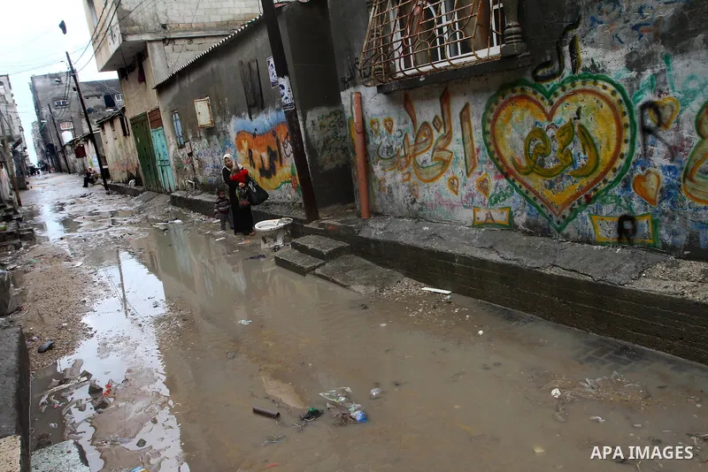 Palestinians walk in a street during the heavy rain of the winter, in the Gaza City, Feb. 19, 2012. Photo by Ashraf Amra