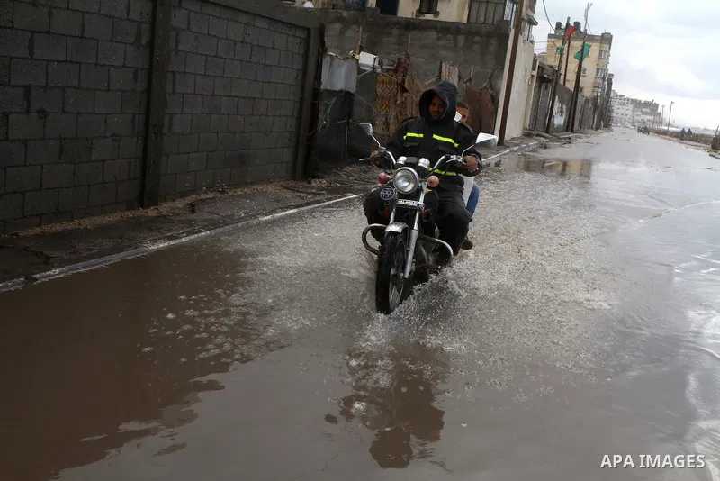 Palestinians walk in a street during the heavy rain of the winter, in the Gaza City, Feb. 19, 2012. Photo by Ashraf Amra