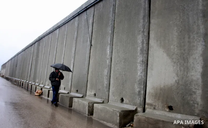 Palestinians walk in a street during the heavy rain of the winter, in west bank City of Ramallah, Feb. 19, 2012. Photo by Issam Rimawi