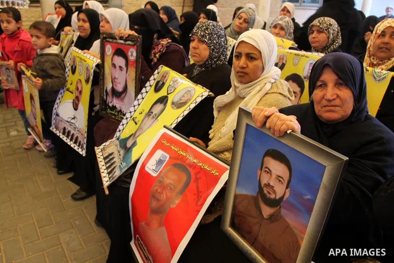 Palestinians women hold posters depicting Palestinian prisoner Khader Adnan, a member of the Islamic Jihad militant group, during a protest in front of the Red Cross in Gaza City, calling for the release of Palestinian p...