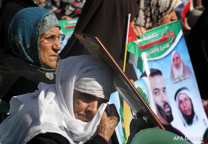 Palestinians women hold posters depicting Palestinian prisoner Khader Adnan, a member of the Islamic Jihad militant group, during a protest in front of the Red Cross in Gaza City, calling for the release of Palestinian p...