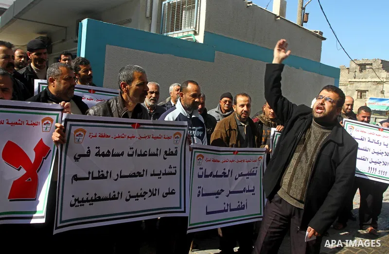 Palestinians take part in a protest in front of the UNRWA (United Nations Relief and Works Agency ) in the Shati refugee camp, in Gaza City, on Feb. 02, 2012 , as UNRWA announced that it will reduce its services for Pale...