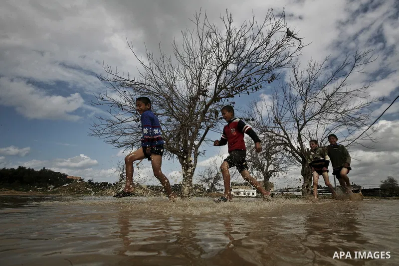 Palestinian children play in a flooded street after heavy rainfall in Jabaliya Refugee camp, the Gaza Strip, 19 February 2012. The Levant region has reportedly seen a high level of rainfall and snow over the past month....