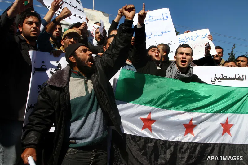 Palestinians holding Syrian flag and banners shout slogans during a protest in solidarity with Syrian people and against the Syrian government headed by president Bashar al-Asad, in Gaza city on Feb. 21,2012. Photo by As...