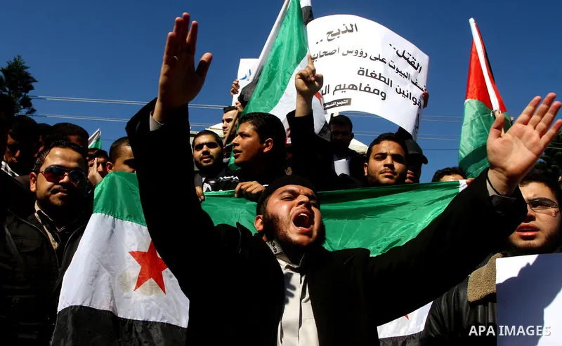 Palestinians holding Syrian flag and banners shout slogans during a protest in solidarity with Syrian people and against the Syrian government headed by president Bashar al-Asad, in Gaza city on Feb. 21,2012. Photo by As...