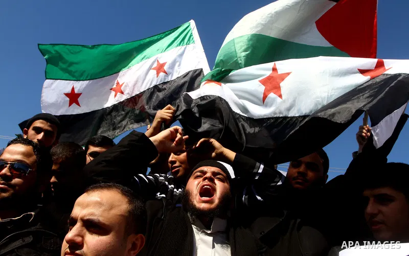 Palestinians holding Syrian flag and banners shout slogans during a protest in solidarity with Syrian people and against the Syrian government headed by president Bashar al-Asad, in Gaza city on Feb. 21,2012. Photo by As...