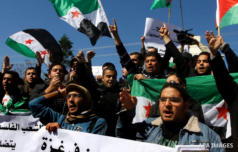 Palestinians holding Syrian flag and banners shout slogans during a protest in solidarity with Syrian people and against the Syrian government headed by president Bashar al-Asad, in Gaza city on Feb. 21,2012. Photo by As...