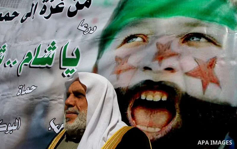 Palestinians holding Syrian flag and banners shout slogans during a protest in solidarity with Syrian people and against the Syrian government headed by president Bashar al-Asad, in Gaza city on Feb. 21,2012. Photo by As...