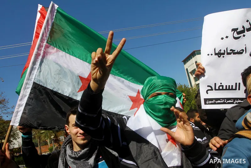 Palestinians holding Syrian flag and banners shout slogans during a protest in solidarity with Syrian people and against the Syrian government headed by president Bashar al-Asad, in Gaza city on Feb. 21,2012. Photo by As...