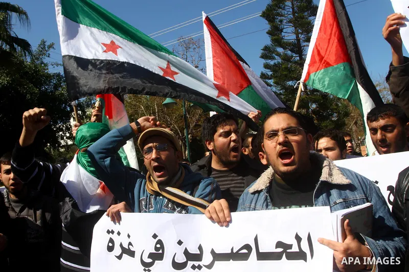 Palestinians holding Syrian flag and banners shout slogans during a protest in solidarity with Syrian people and against the Syrian government headed by president Bashar al-Asad, in Gaza city on Feb. 21,2012. Photo by As...