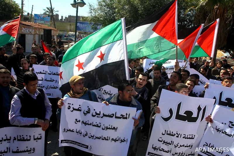 Palestinians holding Syrian flag and banners shout slogans during a protest in solidarity with Syrian people and against the Syrian government headed by president Bashar al-Asad, in Gaza city on Feb. 21,2012. Photo by As...
