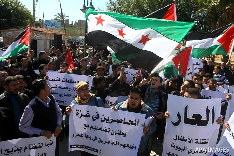 Palestinians holding Syrian flag and banners shout slogans during a protest in solidarity with Syrian people and against the Syrian government headed by president Bashar al-Asad, in Gaza city on Feb. 21,2012. Photo by As...