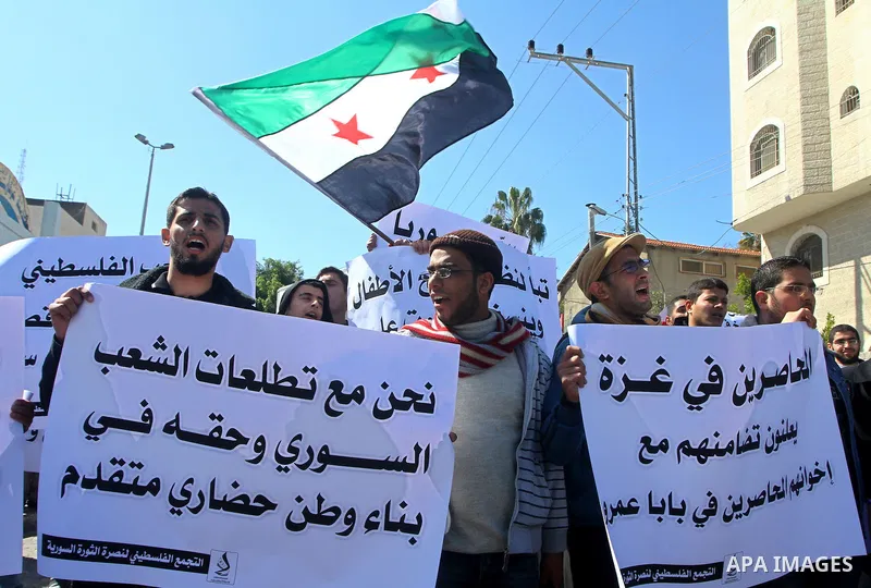 Palestinians holding Syrian flag and banners shout slogans during a protest in solidarity with Syrian people and against the Syrian government headed by president Bashar al-Asad, in Gaza city on Feb. 21,2012. Photo by As...