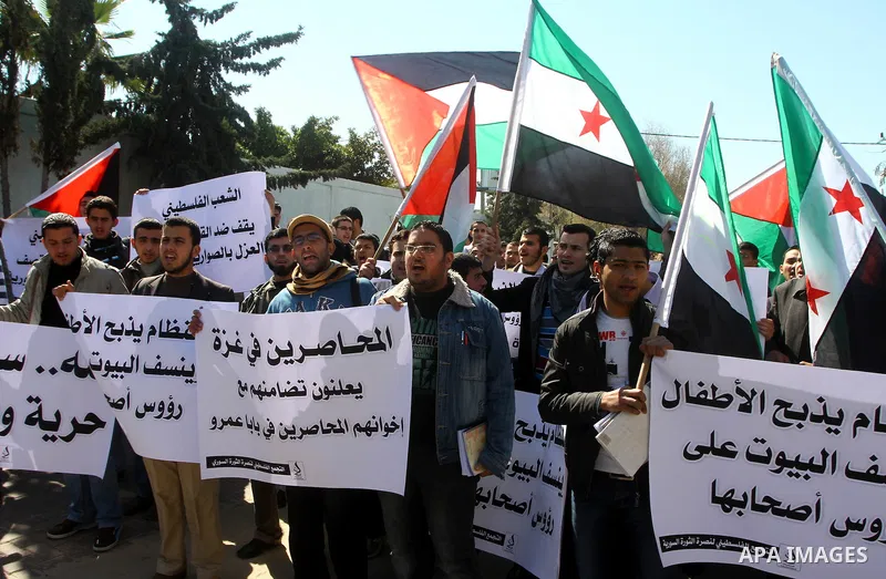 Palestinians holding Syrian flag and banners shout slogans during a protest in solidarity with Syrian people and against the Syrian government headed by president Bashar al-Asad, in Gaza city on Feb. 21,2012. Photo by As...