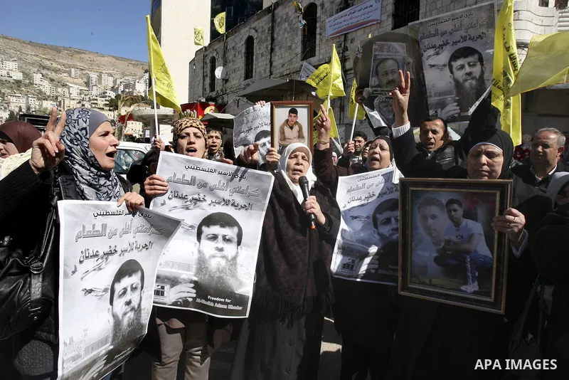 A Palestinian protestor holds a picture of Khader Adnan, 33, a senior member of Islamic Jihad jailed in Israel, during a demonstration in solidarity with Adnan, in the West Bank city of Nablus, on February 21, 2012, shor...