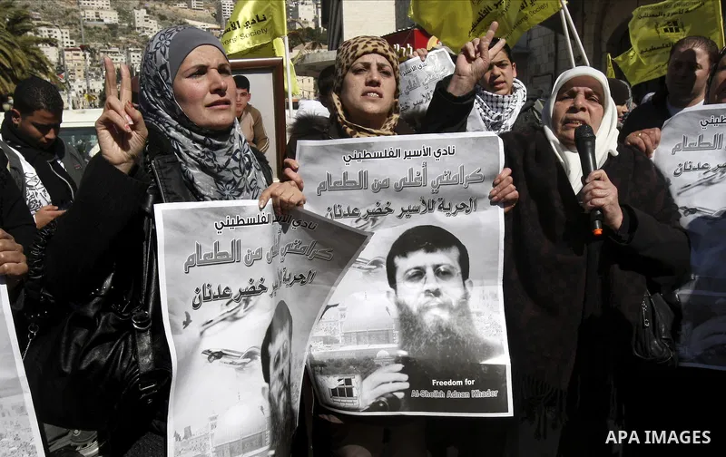 A Palestinian protestor holds a picture of Khader Adnan, 33, a senior member of Islamic Jihad jailed in Israel, during a demonstration in solidarity with Adnan, in the West Bank city of Nablus, on February 21, 2012, shor...