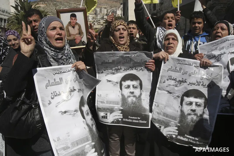 A Palestinian protestor holds a picture of Khader Adnan, 33, a senior member of Islamic Jihad jailed in Israel, during a demonstration in solidarity with Adnan, in the West Bank city of Nablus, on February 21, 2012, shor...