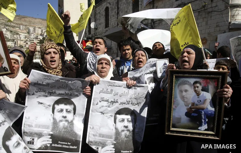 A Palestinian protestor holds a picture of Khader Adnan, 33, a senior member of Islamic Jihad jailed in Israel, during a demonstration in solidarity with Adnan, in the West Bank city of Nablus, on February 21, 2012, shor...