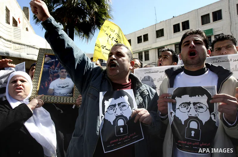 A Palestinian protestor holds a picture of Khader Adnan, 33, a senior member of Islamic Jihad jailed in Israel, during a demonstration in solidarity with Adnan, in the West Bank city of Nablus, on February 21, 2012, shor...
