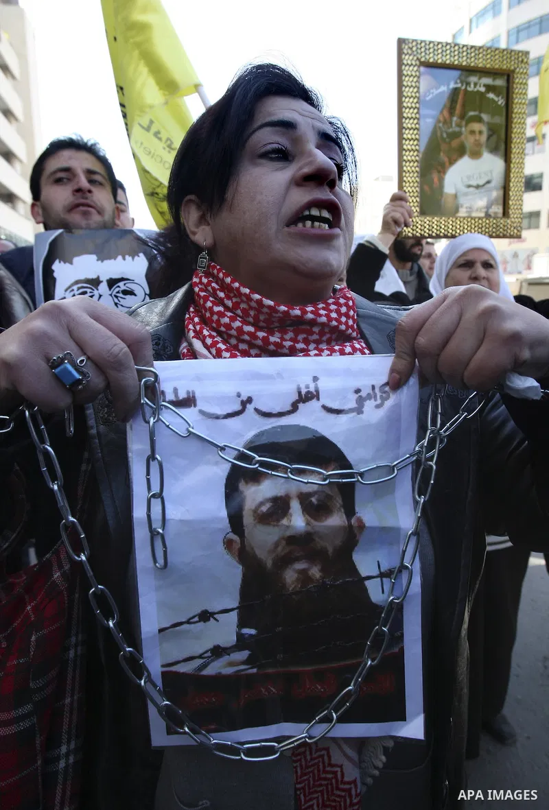 A Palestinian protestor holds a picture of Khader Adnan, 33, a senior member of Islamic Jihad jailed in Israel, during a demonstration in solidarity with Adnan, in the West Bank city of Nablus, on February 21, 2012, shor...