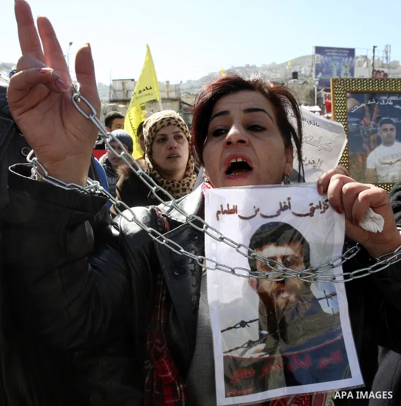 A Palestinian protestor holds a picture of Khader Adnan, 33, a senior member of Islamic Jihad jailed in Israel, during a demonstration in solidarity with Adnan, in the West Bank city of Nablus, on February 21, 2012, shor...